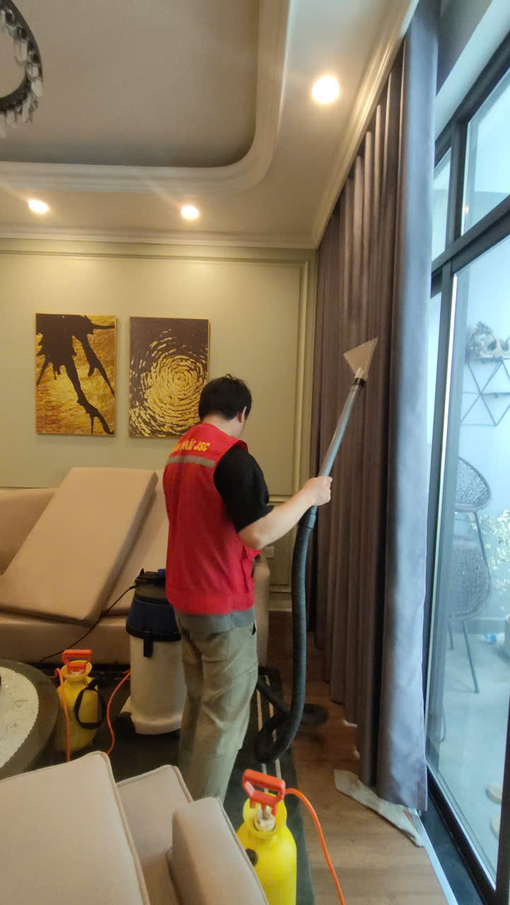Nhân viên đang dùng dụng cụ hút bụi bám bẩn trên rèm