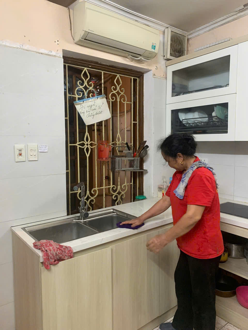 Nhân viên đang dọn dẹp khu vực rửa bát và bếp