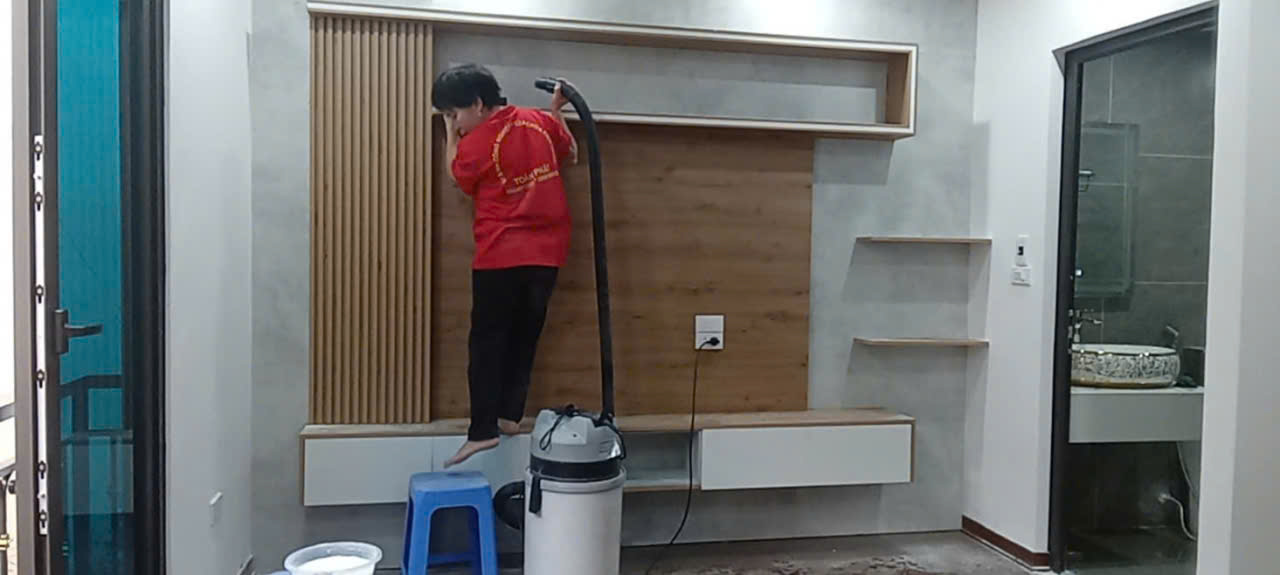 Nhân viên đang hút bụi các góc trong phòng