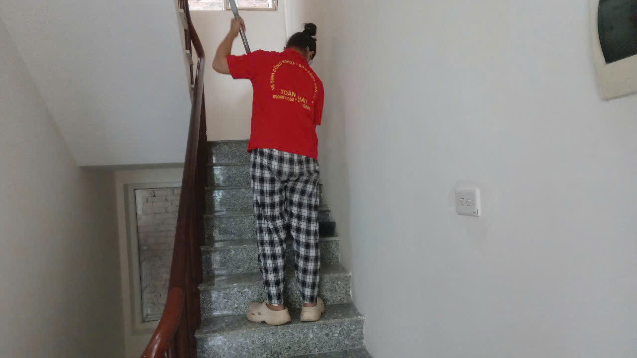 Nhân viên đang quét lau dọn cầu thang