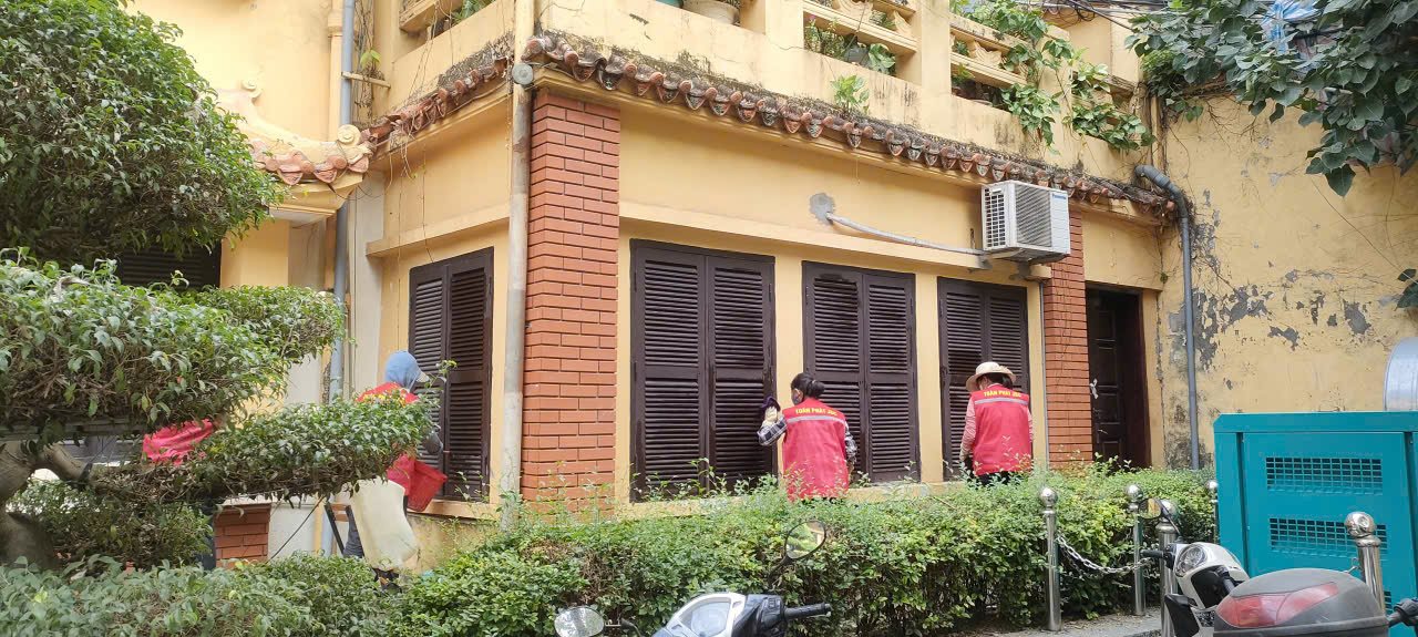 Nhân viên đang dọn dẹp sân vườn của cơ quan