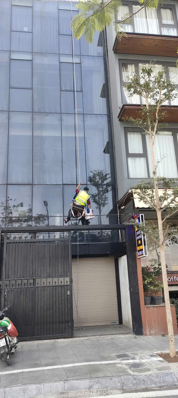 Nhân viên đang vệ sinh kính bên ngoài tòa nhà