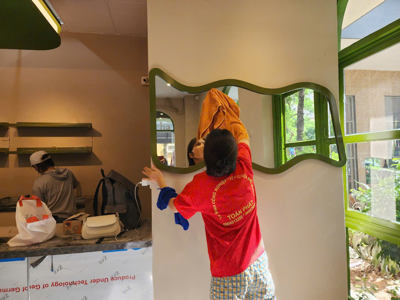 Nhân viên đang phụ trách dọn dẹp khung kính trong không gian