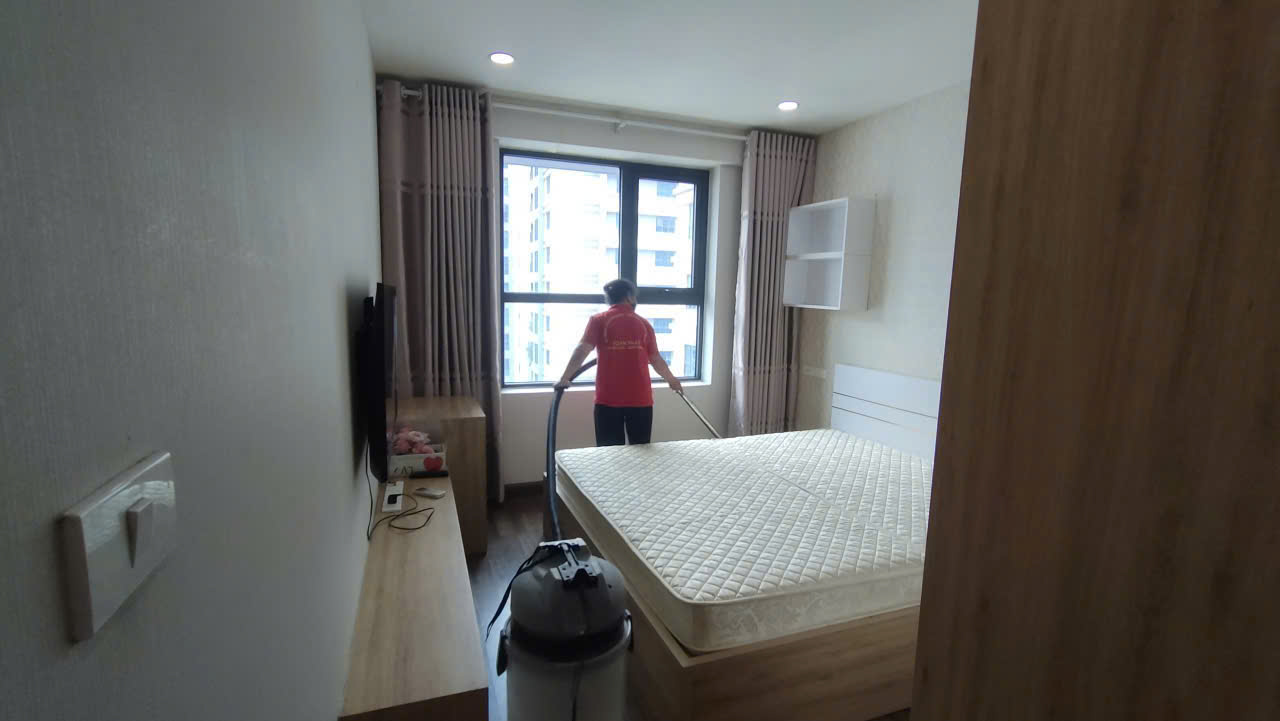 Nhân viên đang dọn dẹp hút bụi phòng ngủ