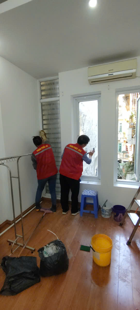 Nhân viên đang vệ sinh kính trong phòng của tòa nhà
