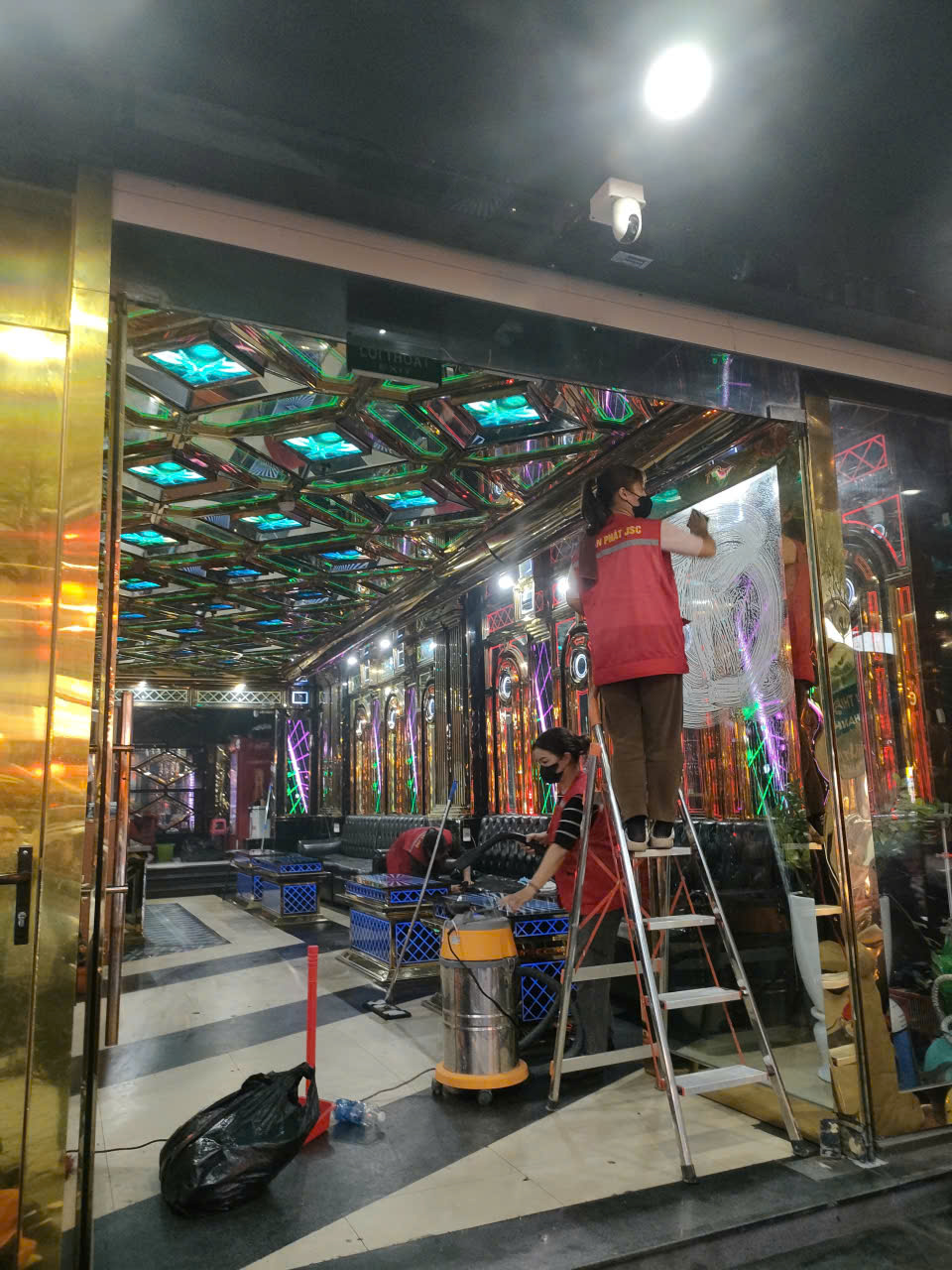 Nhân viên đang lau dọn trên trần và cửa kính