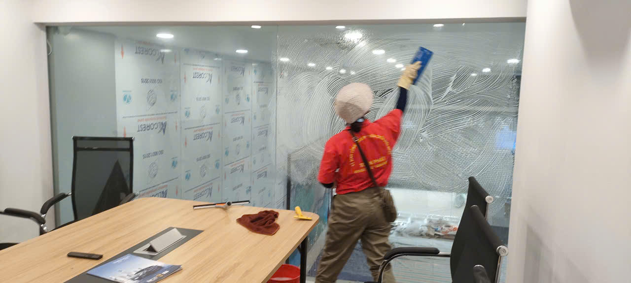 Nhân viên đang vệ sinh kính phòng làm việc của tòa nhà